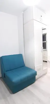 a blue couch in a room with a mirror at Sarajevska Studio & Apartment in Belgrade