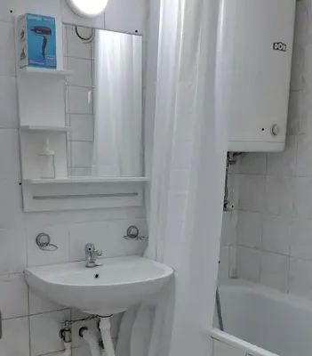 a bathroom with a sink and a mirror and a tub at Sarajevska Studio & Apartment in Belgrade