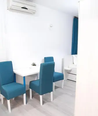 a room with a table and two blue chairs at Sarajevska Studio & Apartment in Belgrade