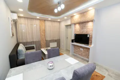 a living room with a table and chairs and a television at New Belgrade Center 2 in Belgrade