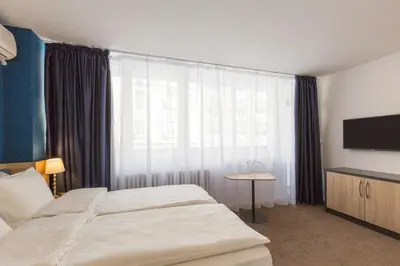 a hotel room with two beds and a flat screen tv at Premium Crown Suites in Belgrade