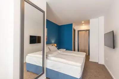 a bedroom with a bed and a mirror at Premium Crown Suites in Belgrade
