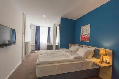 a bedroom with a bed with a blue wall at Premium Crown Suites in Belgrade