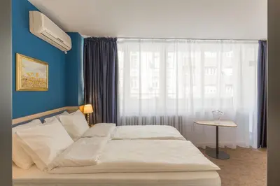 a bedroom with a bed and a window with a table at Premium Crown Suites in Belgrade