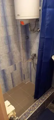a bathroom with a shower with a blue shower curtain at A modest place in Belgrade