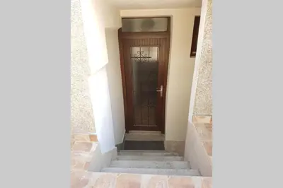 a wooden door in a hallway with stairs at A modest place in Belgrade