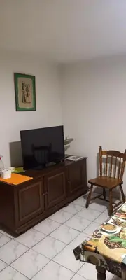 a living room with a flat screen tv and a chair at A modest place in Belgrade