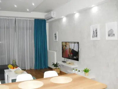 a living room with a table and a tv on a wall at Belgrade Waterfront Lux 2 in Belgrade