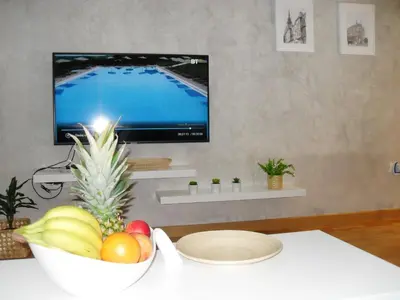 a bowl of fruit sitting on a table with a television at Belgrade Waterfront Lux 2 in Belgrade