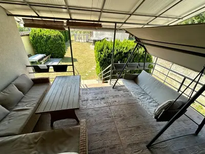 a screened in porch with a couch and a table at Villa Ponte in Pančevo