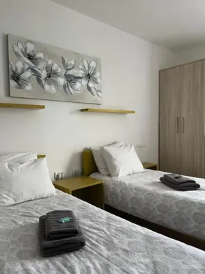 a hotel room with two beds with towels on them at Villa Ponte in Pančevo