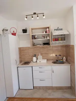 a small kitchen with white cabinets and a sink at Studio 17 in Belgrade