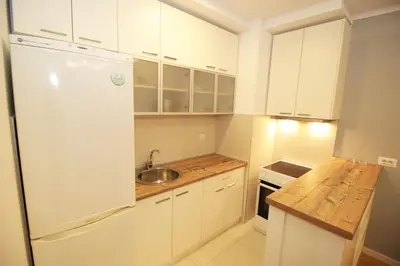 a kitchen with white cabinets and a sink and a refrigerator at Apartment A block Daja in Belgrade