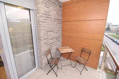 a table and chairs on a balcony with a window at Apartment A block Daja in Belgrade