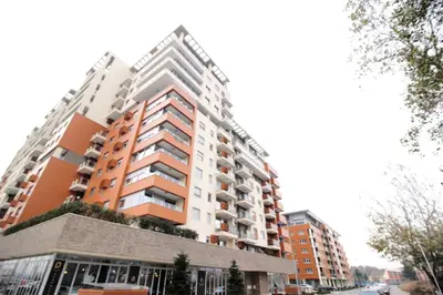 a tall apartment building with orange and white at Apartment A block Daja in Belgrade