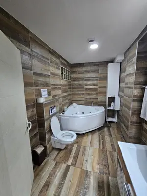 a bathroom with a tub and a toilet and a sink at Apartman Viktor 2 Jacuzzi in Belgrade