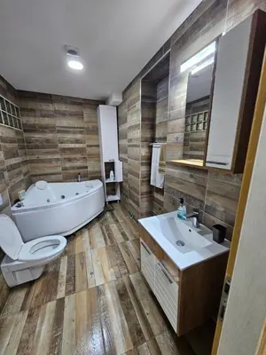 a bathroom with a tub and a toilet and a sink at Apartman Viktor 2 Jacuzzi in Belgrade