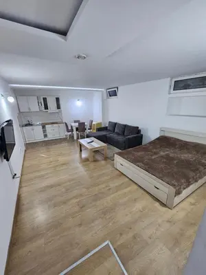 a bedroom with a bed and a couch and a table at Apartman Viktor 2 Jacuzzi in Belgrade