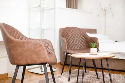 two chairs and a table in a room with a bed at 1st Belgrade Apartment in Belgrade