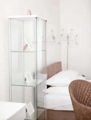 a glass cabinet in a bedroom with a bed at 1st Belgrade Apartment in Belgrade