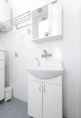 a white bathroom with a sink and a mirror at 1st Belgrade Apartment in Belgrade