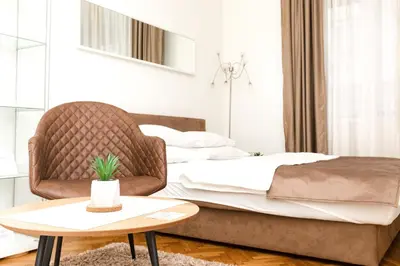a bedroom with a bed with a chair and a table at 1st Belgrade Apartment in Belgrade