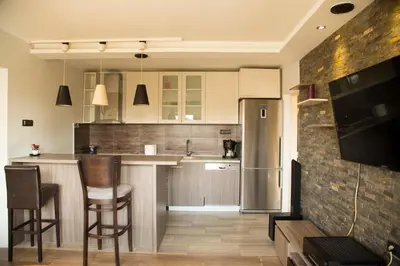 a kitchen with a sink and a counter with chairs at Ahoy Belgrade Luxury Apartment in Belgrade