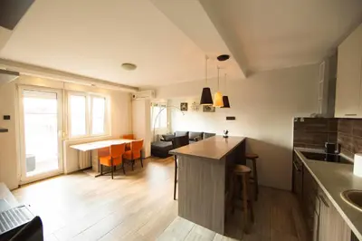 a kitchen and living room with a table and chairs at Ahoy Belgrade Luxury Apartment in Belgrade