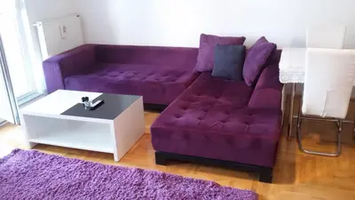 a purple couch and a white table in a living room at Lili in Arandjelovac