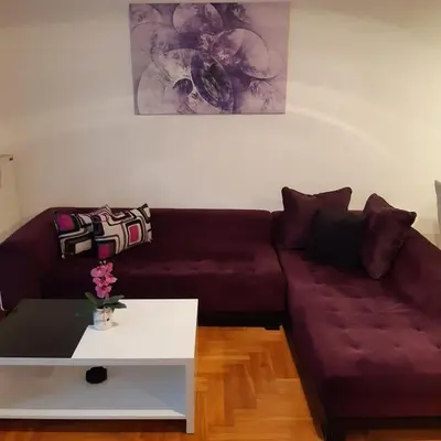 a living room with a purple couch and a white table at Lili in Arandjelovac