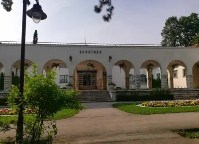 a building with a courtyard with flowers in front of it at Lili in Arandjelovac