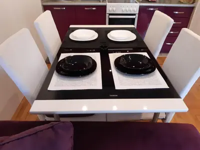 a black and white stove in a kitchen with white chairs at Lili in Arandjelovac