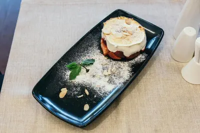 a black plate with a dessert on a table at Central Point Hotel Beograd in Belgrade