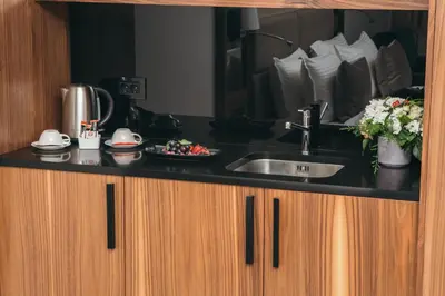 a kitchen counter with a sink and a mirror at Central Point Hotel Beograd in Belgrade
