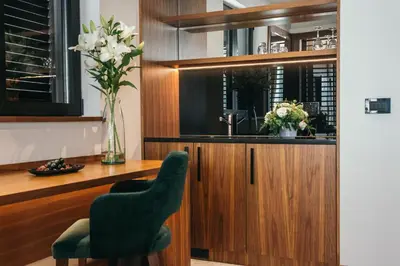 a dining room with a green chair and a desk at Central Point Hotel Beograd in Belgrade