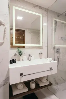 a white bathroom with a sink and a mirror at Central Point Hotel Beograd in Belgrade