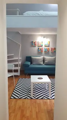 a living room with a blue couch and a table at Liberty in Belgrade