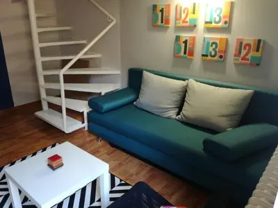 a living room with a blue couch and a white table at Liberty in Belgrade