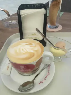 a cup of coffee on a plate with a spoon at Liberty in Belgrade