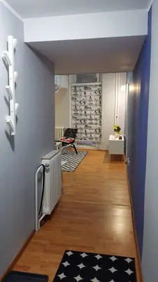 a hallway with blue walls and wooden floors and a room at Liberty in Belgrade