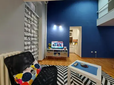 a living room with a chair and a tv at Liberty in Belgrade