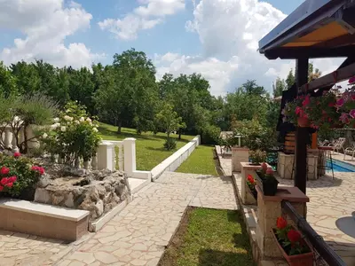 a garden with flowers and a white fence at VILA PEKEČ in Mala Moštanica