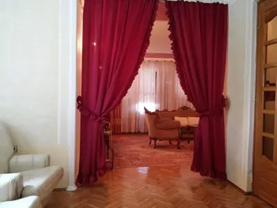 a living room with red curtains and a table at VILA PEKEČ in Mala Moštanica