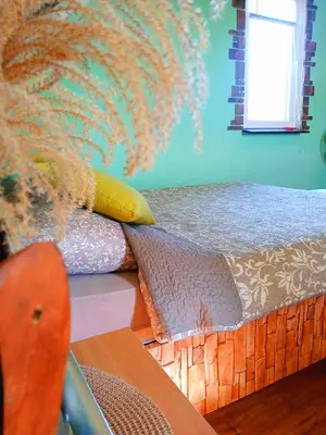 a bedroom with a bed with a pillow and a window at Sunčana Strana Fruške Gore - veliko imanje sa kucom za odmor in Velika Remeta