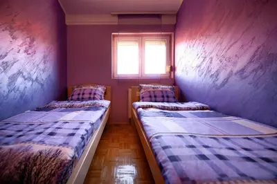 two beds in a small room with a window at Apartman 23 in Lazarevac