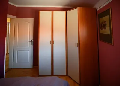 a bedroom with two white cabinets and a door at Apartman 23 in Lazarevac