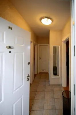 a hallway with a white door and a tile floor at Apartman 23 in Lazarevac