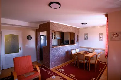 a living room with a table and a kitchen at Apartman 23 in Lazarevac
