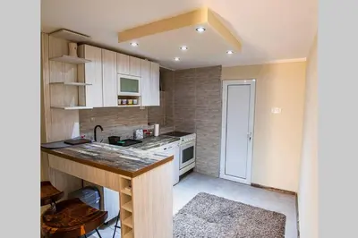 a small kitchen with white cabinets and a counter at Colorway Apartment in Belgrade