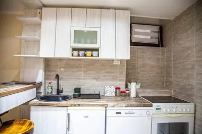 a kitchen with white cabinets and a sink at Colorway Apartment in Belgrade